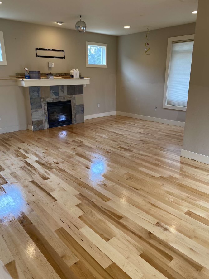 Wide plank oak hardwood installation with brick fireplace